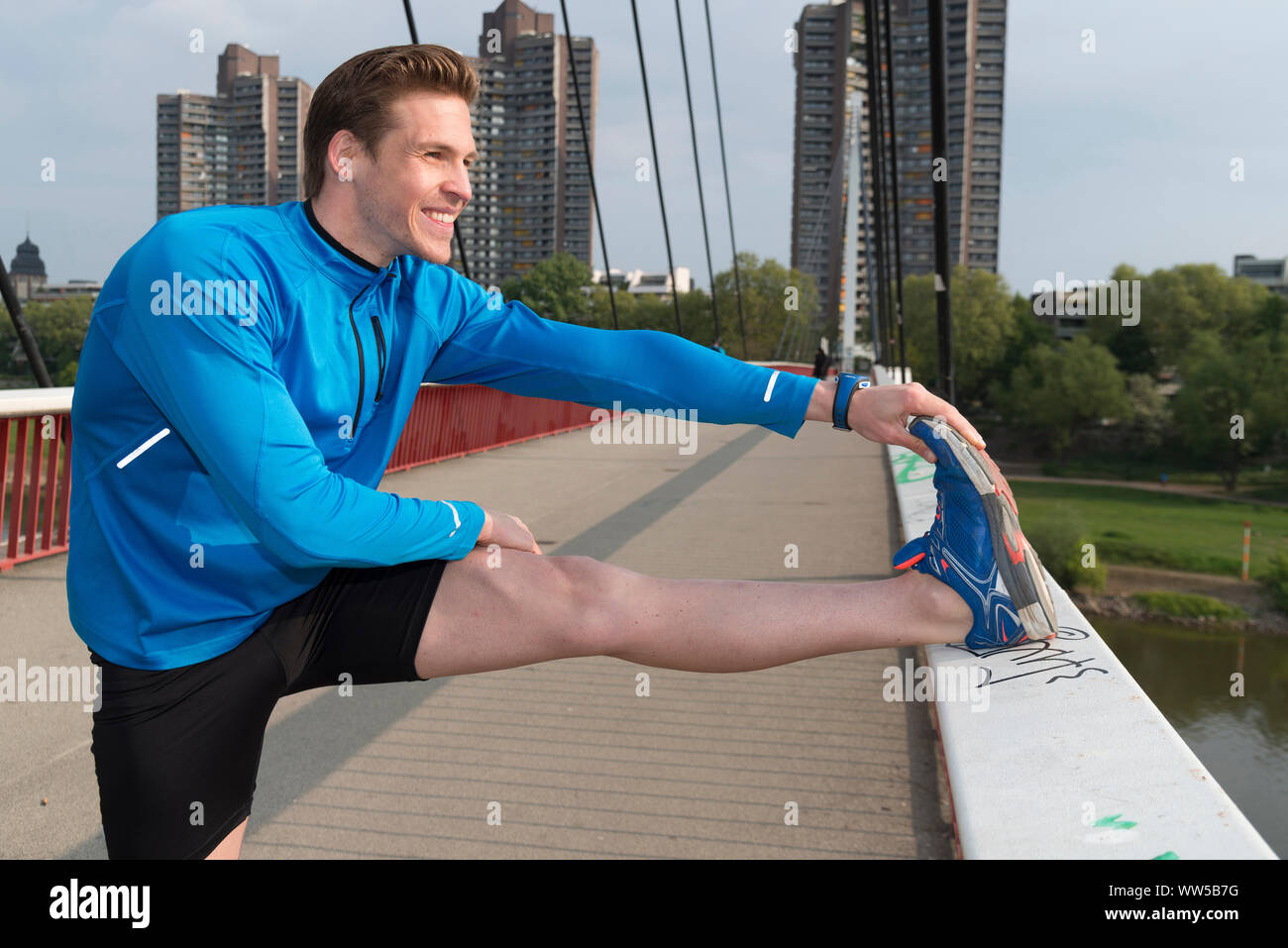 L'homme s'étend avec le pied sur la balustrade Banque D'Images