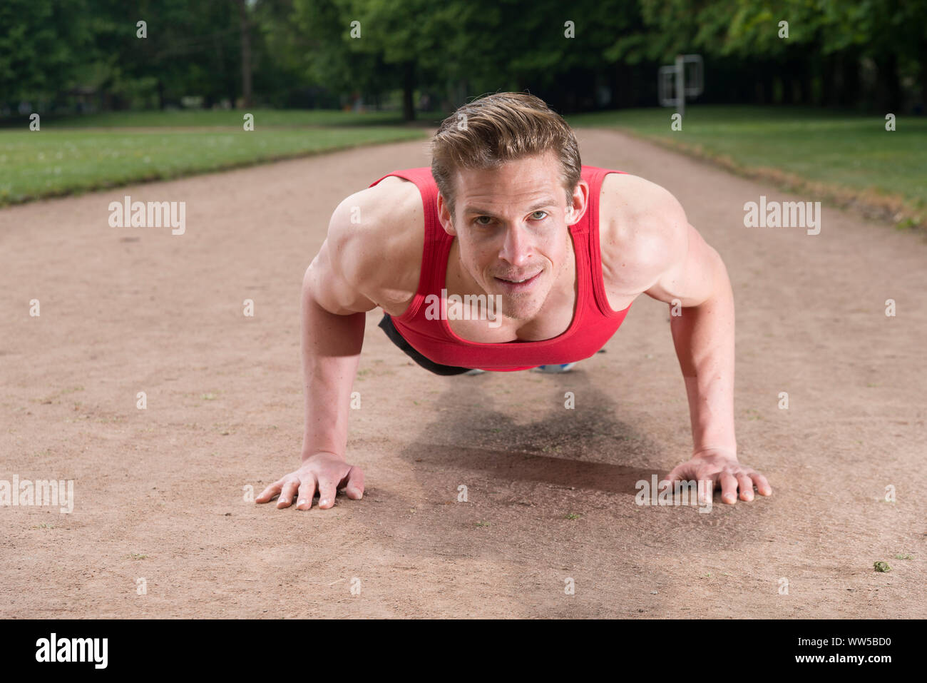 L'homme dans des vêtements de sport, push-ups, looking at camera Banque D'Images