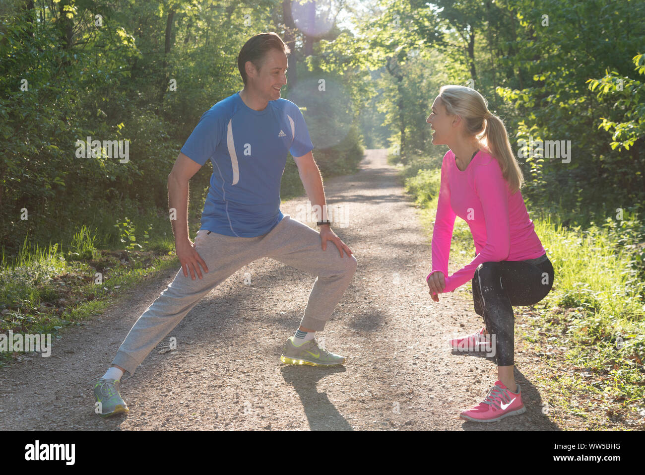 Couple in sportswear réchauffe dans la forêt Banque D'Images