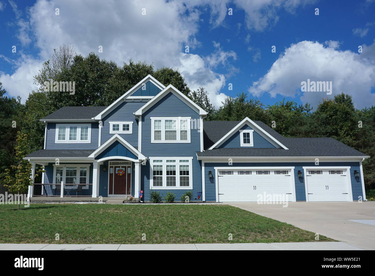 Deux étages maison de banlieue à l'extérieur bleu et trois garage automobile Banque D'Images