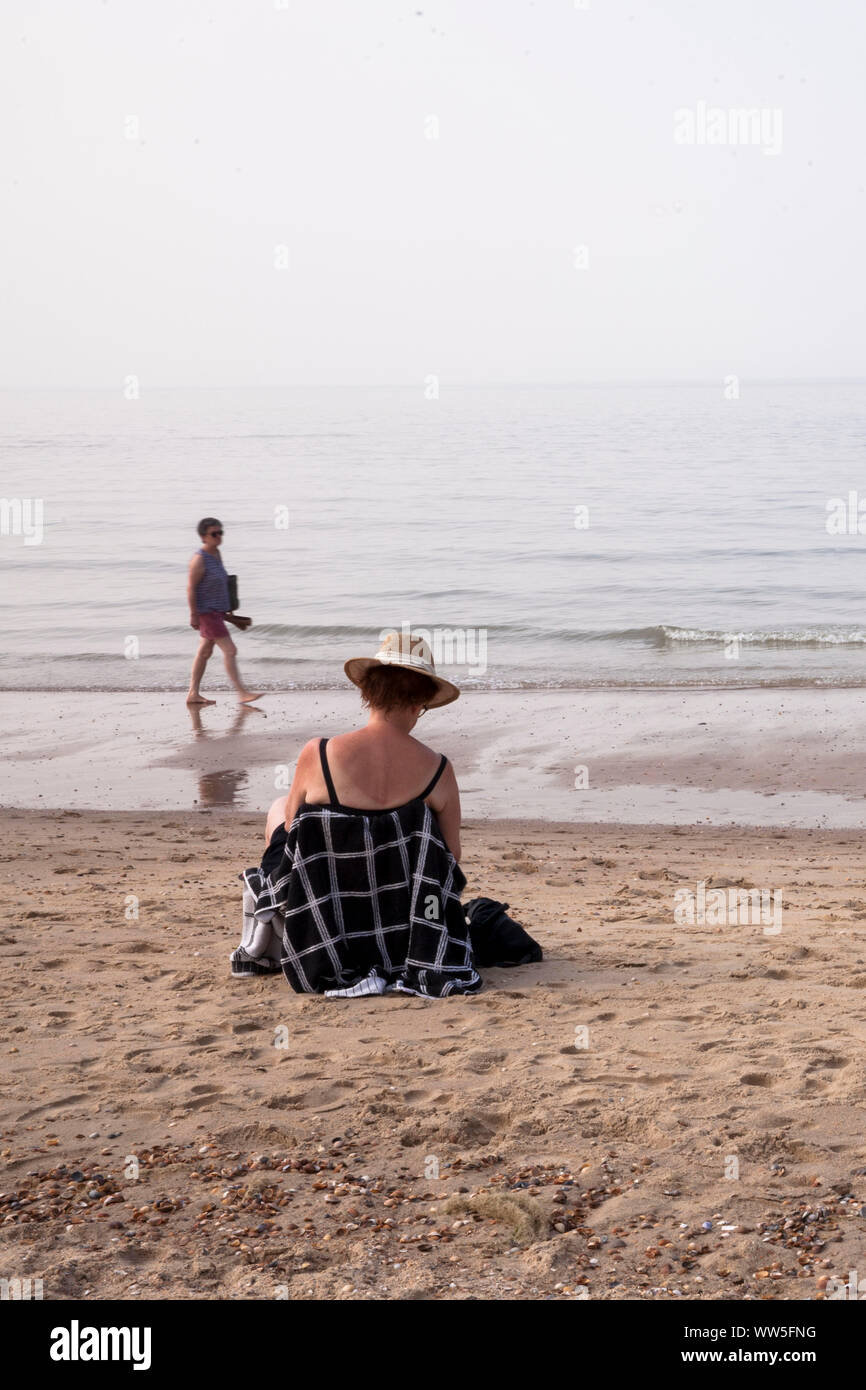 Femme assise sur la plage près de Rovinj sur la presqu'île Walcheren, Zélande, Pays-Bas. Frau sitzt am Strand bei Oostkapelle auf Walcheren, Zee Banque D'Images