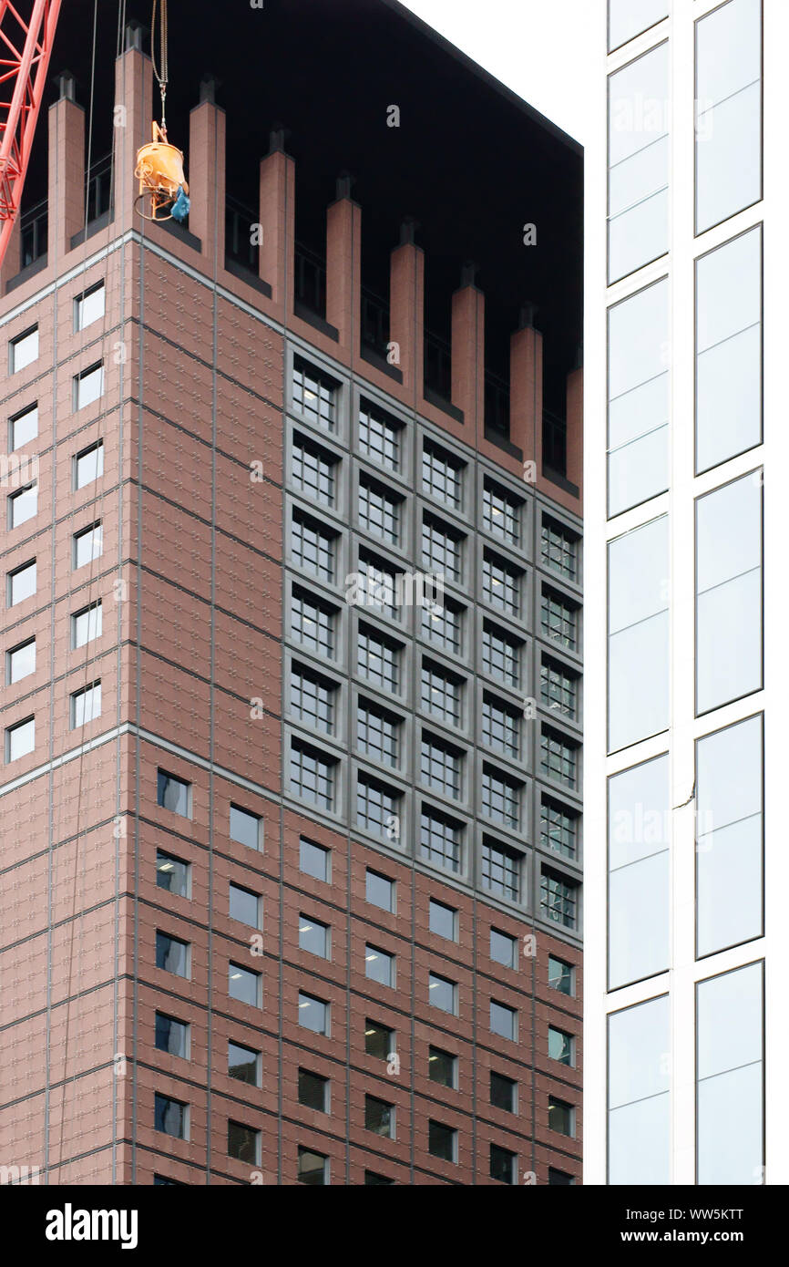 Photographie des matériaux de construction qui est portée par une grue entre deux grands immeubles, Banque D'Images
