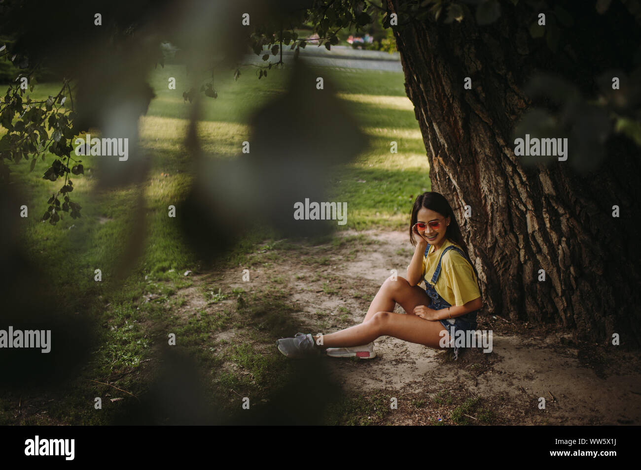 Femme assise sous un arbre dans le parc, Serbie Banque D'Images