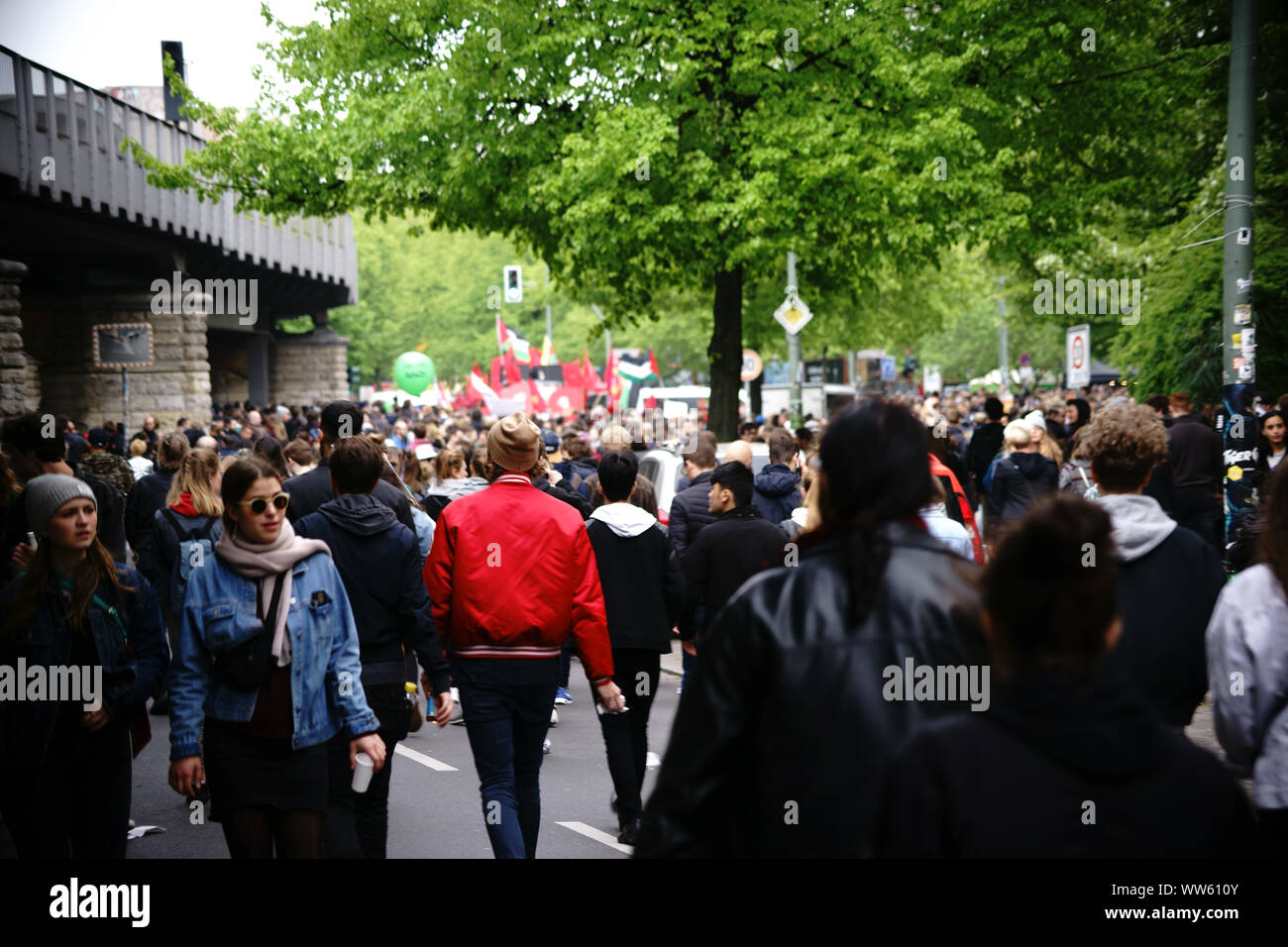 Les passants, manifestants et badauds marchant le long de l'underground rails dans Kreuzberg, pendant la manifestation du 1er mai à Berlin. Banque D'Images