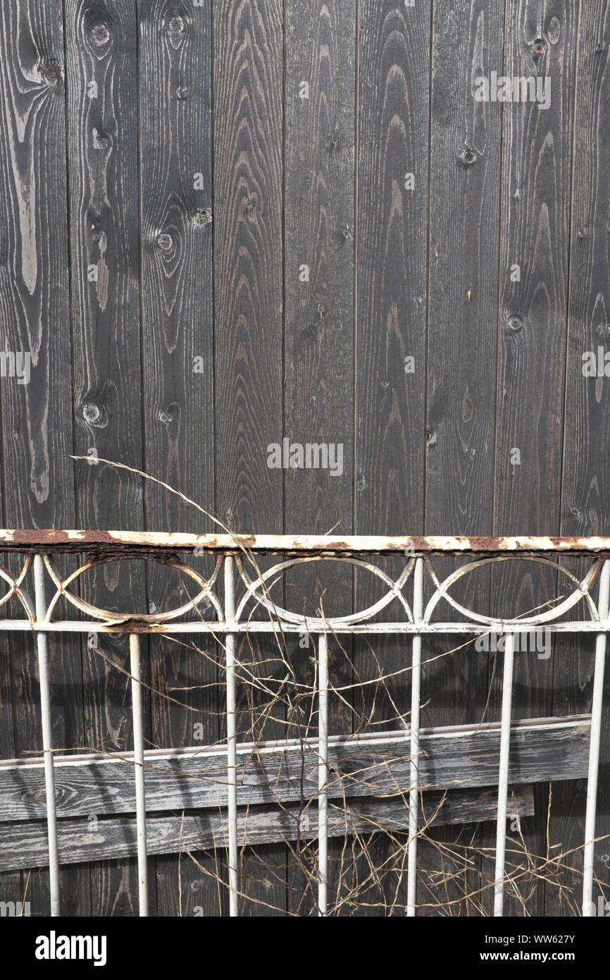 Rusty clôture devant le mur en bois de Banque D'Images