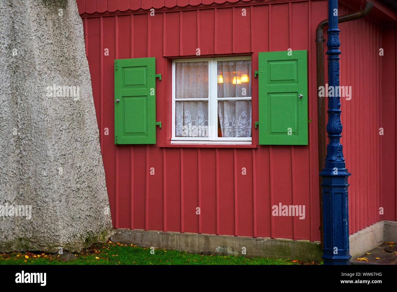 Maison Rouge, avec fenêtre avec des volets verts, éclairé Banque D'Images