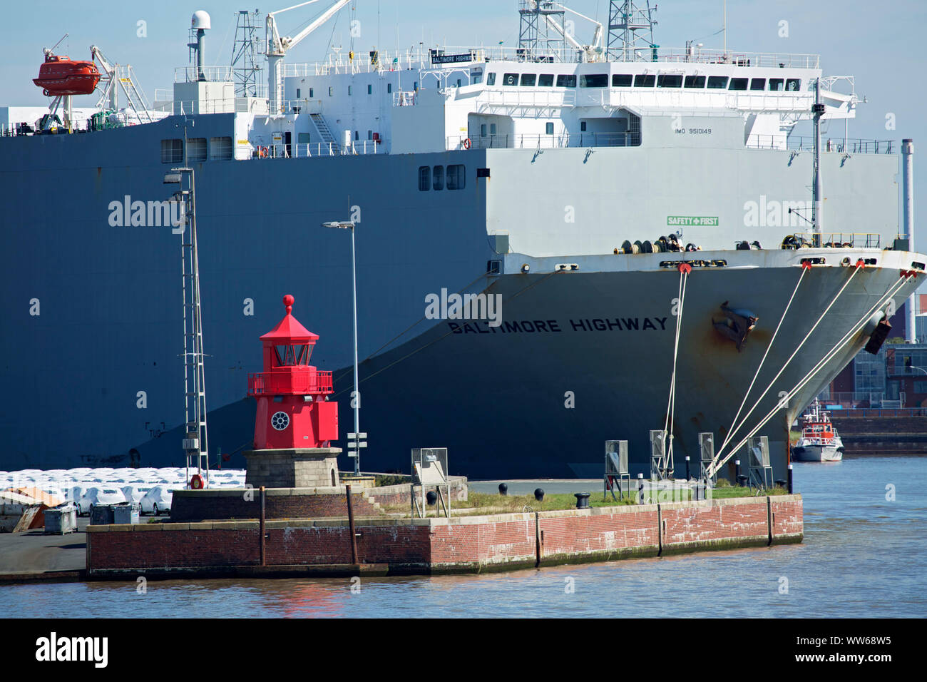 Phare (construit 1901) à l'ouest mole du port d'Emden en avant d'un navire RoRo au quai de chargement voiture d'Emden. Banque D'Images