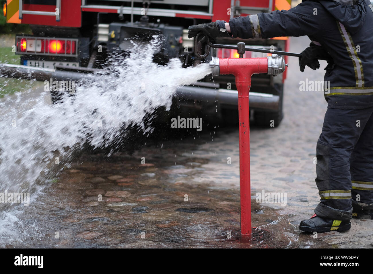 Le pompier s'ouvre une bouche d'incendie à éteindre un feu Banque D'Images