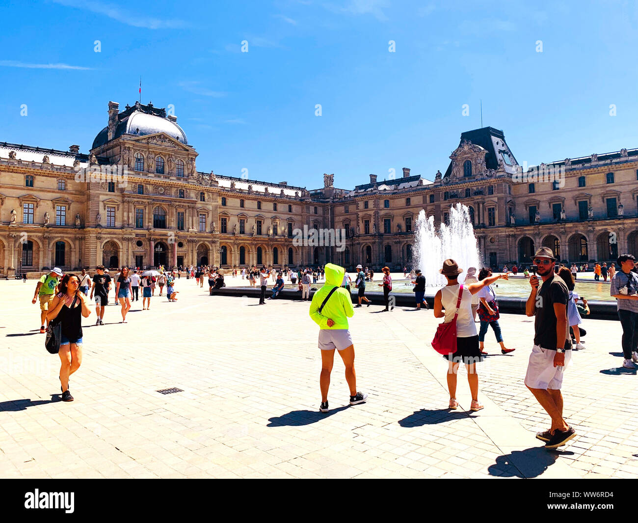 Paris / France - Juillet 6, 2019 : place principale de célèbre musée du Louvre. De nombreux touristes marchant autour. Jour d'été ensoleillé. Banque D'Images