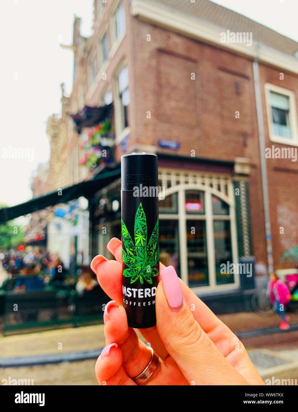 Amsterdam / Pays-Bas - 11 juillet 2019 : Noir plus léger en main avec l'icône féminine de la marijuana sur fond d'un café dans le centre d'Amsterdam. Banque D'Images
