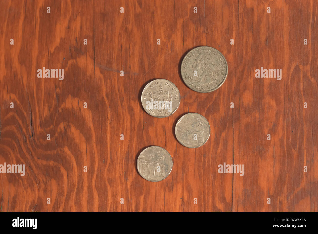 Monterrey, Mexique - 11 septembre 2019 : monnaie cubaine, cuc, d'une valeur de cinq cents, dix cents et dollars US d'une valeur de vingt-cinq cents sur un bureau en bois. Colle Banque D'Images