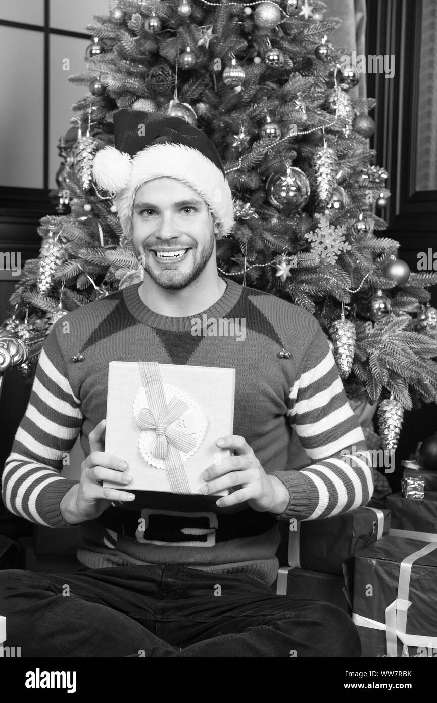 Homme fêter le nouvel an ou de noël. Homme santa hat célébrer noël intérieur baroque décoré sapin et cadeaux. Le père noël et christma Banque D'Images