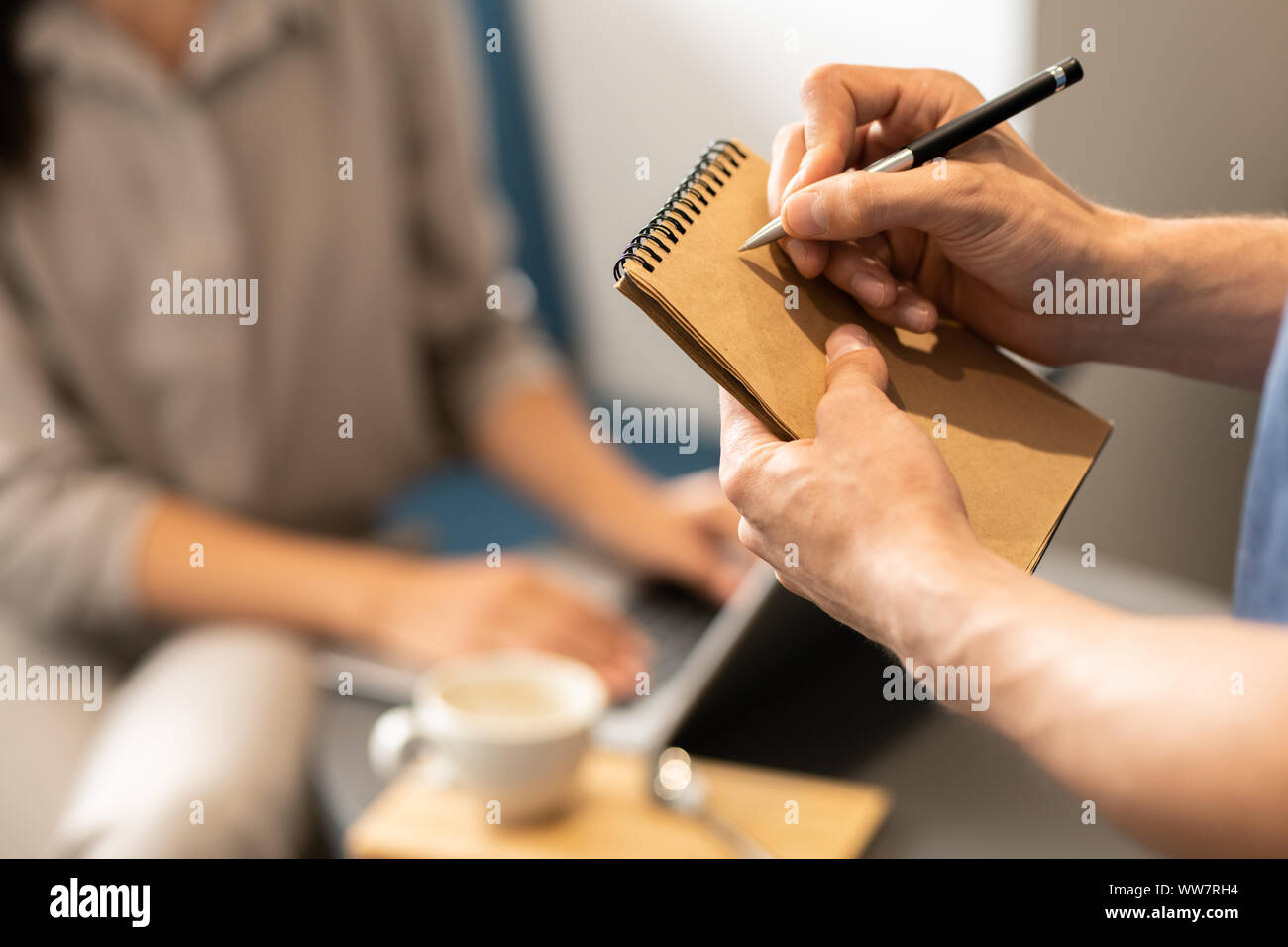 Jeune serveur allant d'écrire afin de client sur la page vierge de notepad Banque D'Images