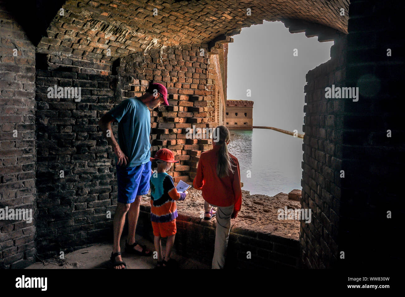 Deux enfants regarder par une fenêtre, à l'historique Fort Jefferson avec leur papa sur une visite à Dry Tortugas National Park, en Floride. Banque D'Images
