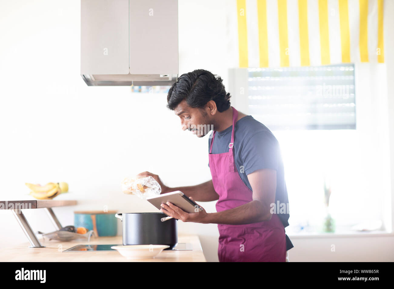 Jeune homme indien dans une cuisine cuisson Banque D'Images