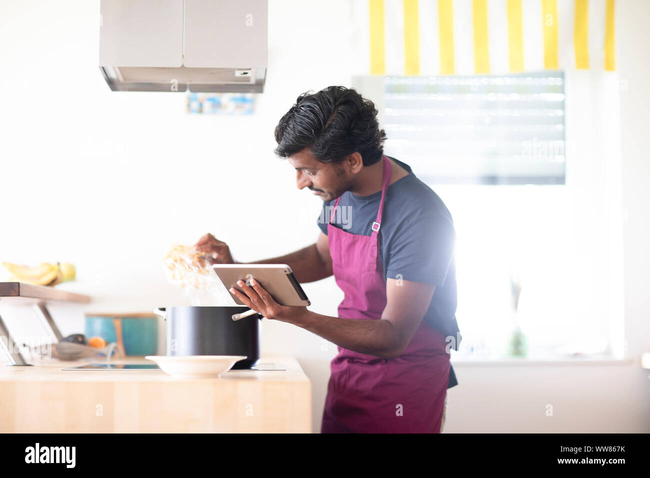 Jeune homme dans la cuisine une cuisine avec tablet Banque D'Images