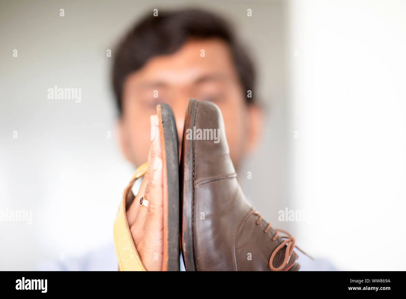 Sandale et chaussure dans les mains d'un jeune homme Banque D'Images