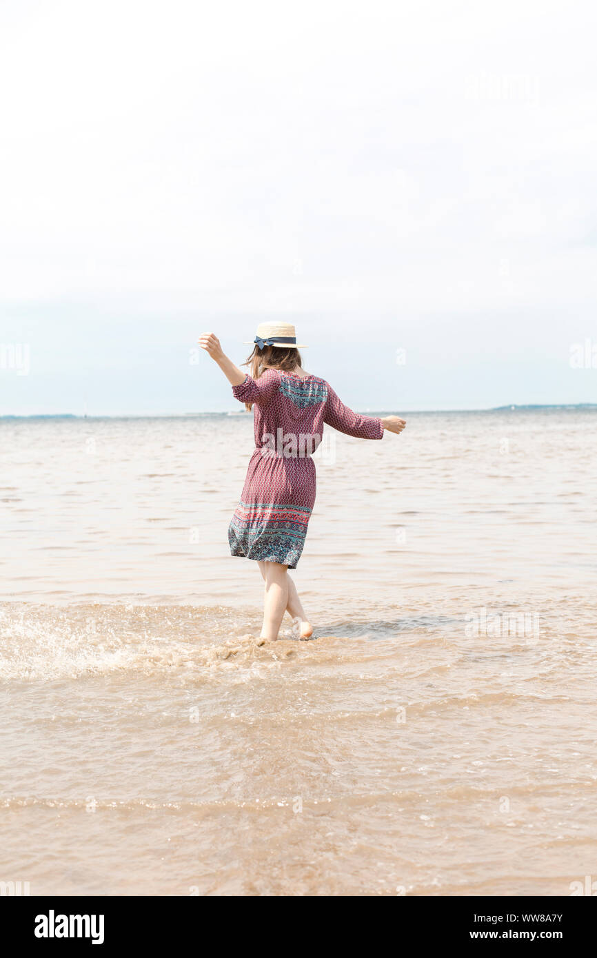 Jeune femme s'éclabousser dans l'eau avec ses pieds Banque D'Images