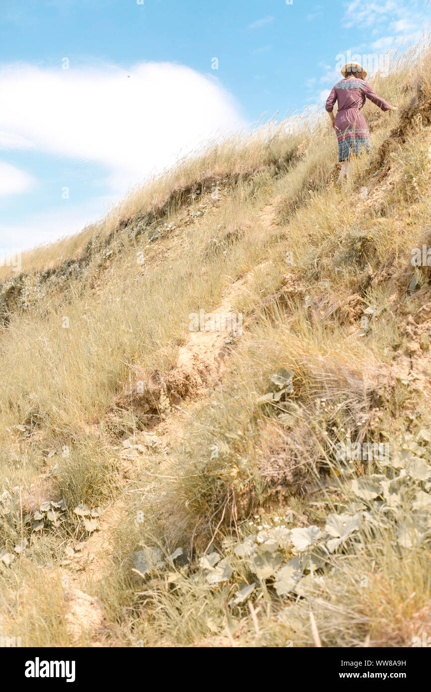 Jeune femme de grimper la côte raide Banque D'Images