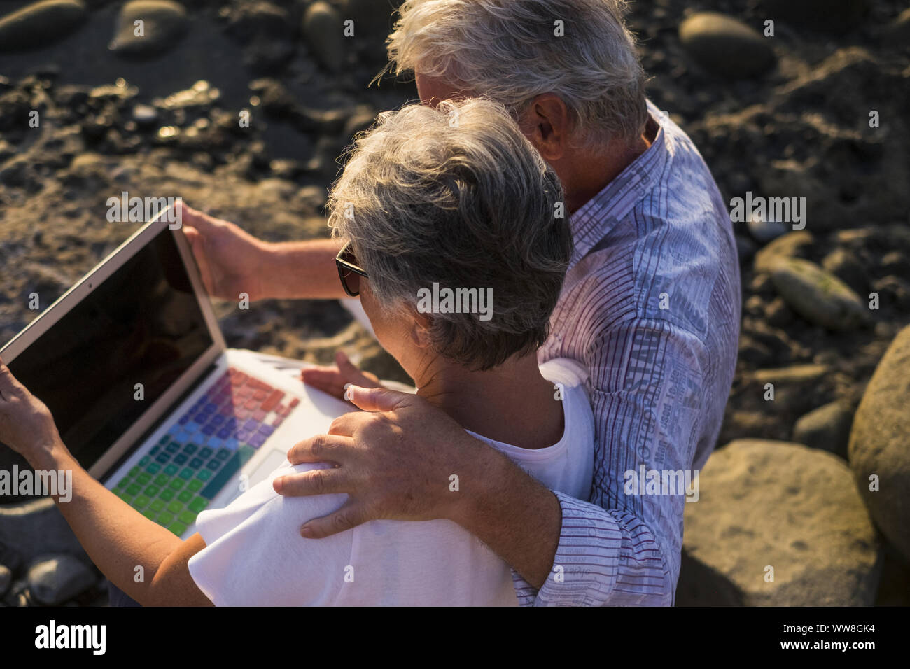 Concept de vacances, la technologie, le tourisme, les voyages et les gens - happy senior couple with tablet pc ordinateur sur la plage de galets, cheveux blancs Banque D'Images