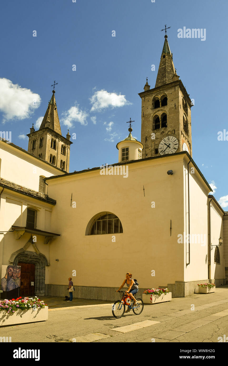 Vue latérale de la cathédrale d'aoste avec les deux clochers Romane (11ème siècle) et les touristes dans une journée ensoleillée, Aoste, vallée d'aoste, Italie Banque D'Images
