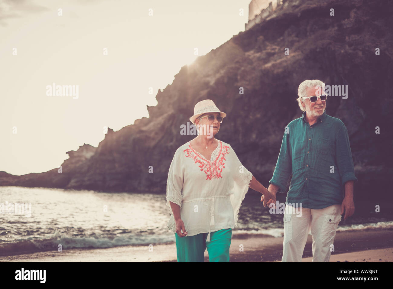 Happy senior couple in love waing souriant et profiter de l'heure d'été sur la plage et la vie à la retraite de leur nouvelle vie ensemble après des années de travail. une place pittoresque avec l'océan et la côte Banque D'Images