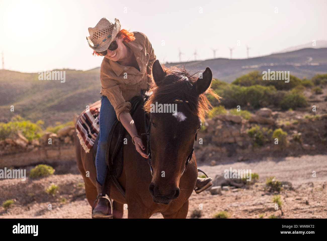 Cheveux Rouges joyeuse dame monter un beau cheval brun dans l'amitié et profiter de la journée ensemble. relation et la zoothérapie. heureux et la joie de vie en contact avec la nature Banque D'Images