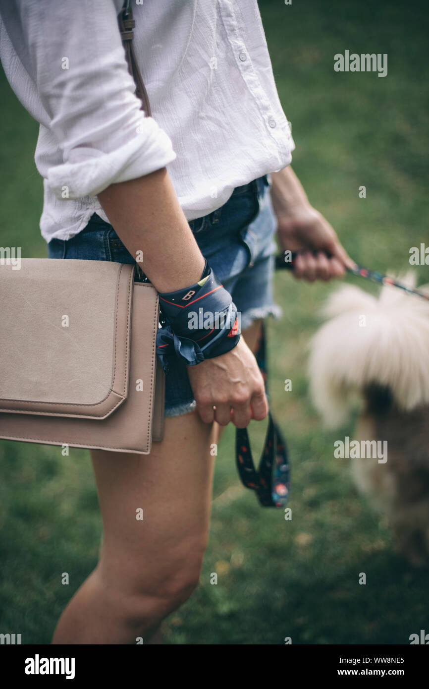 Jeune femme marchant avec son chien dans le parc Banque D'Images