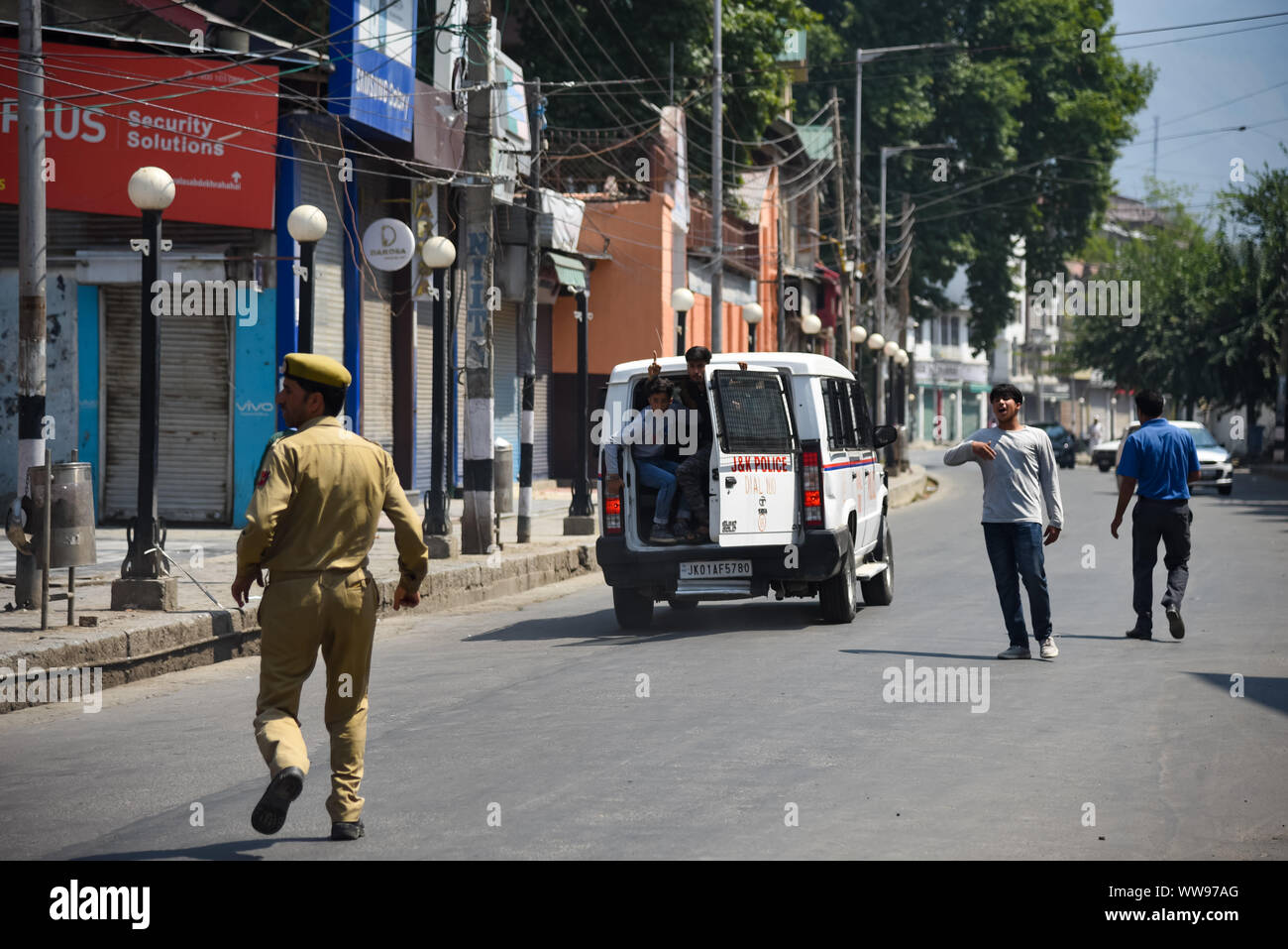 Srinagar, Inde. 14Th Sep 2019. Un policier indien s'exécute après garçon musulman chiite du Cachemire comme ils ont sorti 8ème Mouharram procession à Srinagar.compétentes le dimanche 8e jour de l'Ashoura serré pendant un mois, un verrou de sécurité dans la principale ville du Cachemire Srinagar après sa rupture des processions de fidèles qui ont défié une interdiction. La procession a été prise au cours de Muharram, le premier mois du calendrier islamique qui a débuté le 1er septembre cette année pour commémorer le grand sacrifice de l'Imam Hussain (AS) et ses compagnons. Credit : SOPA/Alamy Images Limited Live News Banque D'Images