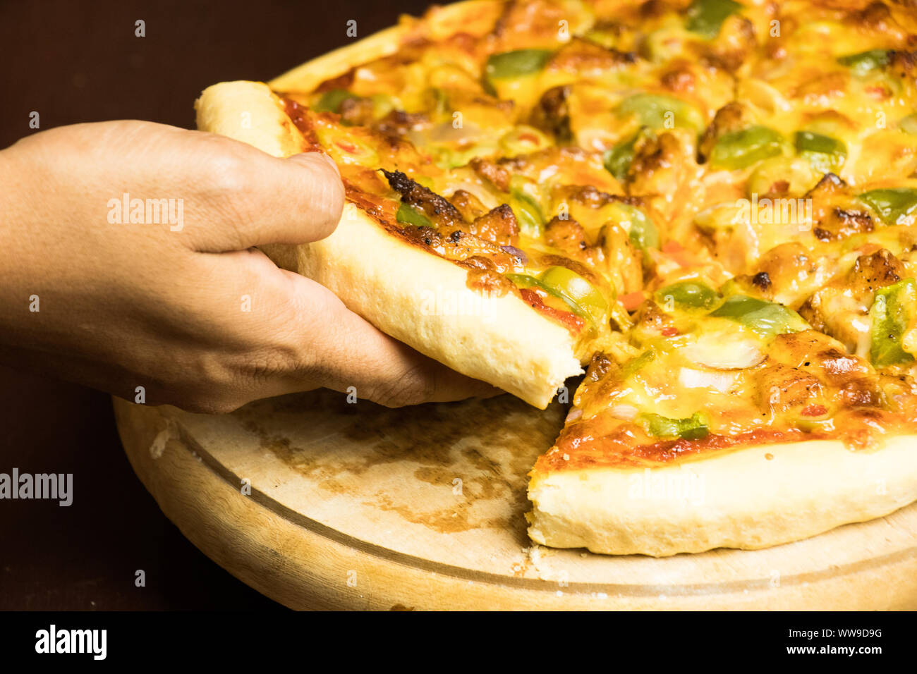 Pan Pizza slice de prendre part avec vue côté bois marron foncé Banque D'Images
