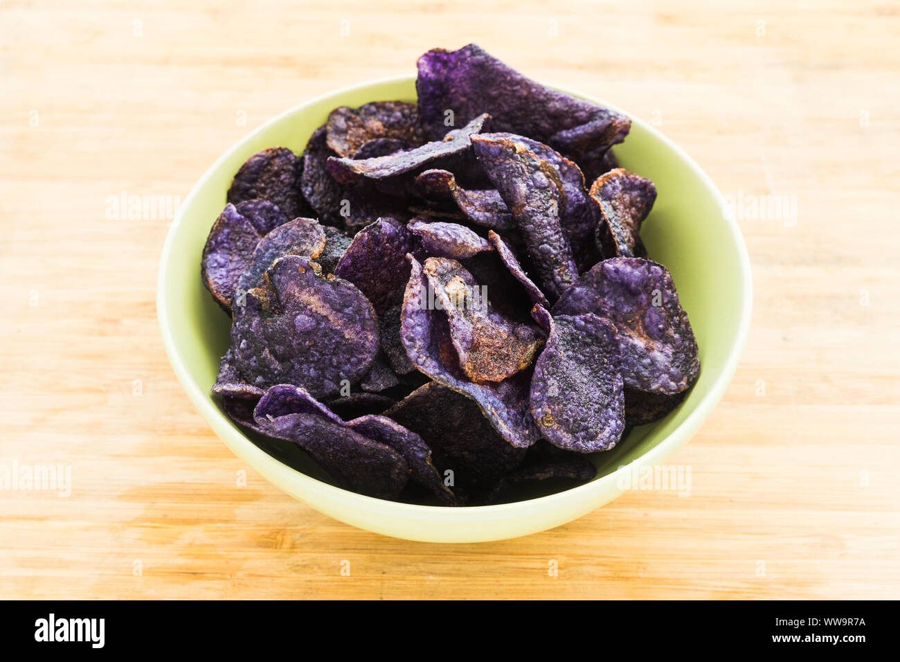 Un tas de jetons de couleur violet sur fond de bois Banque D'Images