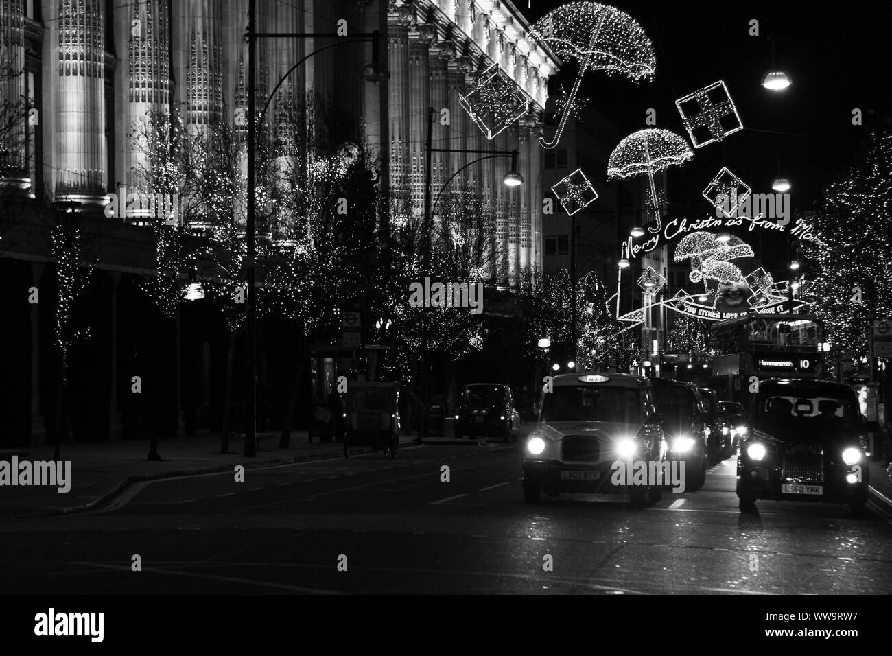 Londres de nuit avec les taxis noirs de Londres, Oxford street et Selfridges store les lumières de Noël. L'imagerie authentique. scène de nuit dans le West fin. W1. District postal. Banque D'Images