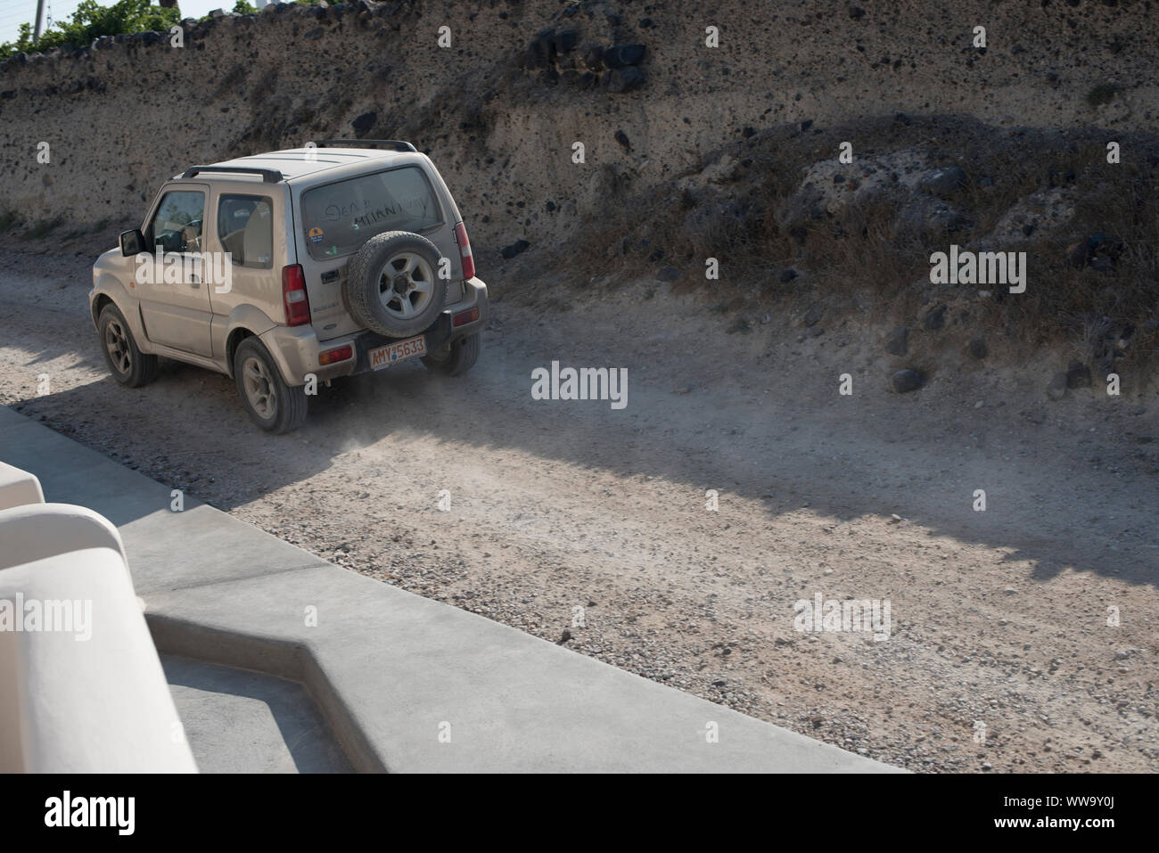 Santorin, Grèce - 23 juin 2018 : Un lecteurs petits VUS le long d'un chemin de terre à Santorin à la mi-été. Banque D'Images