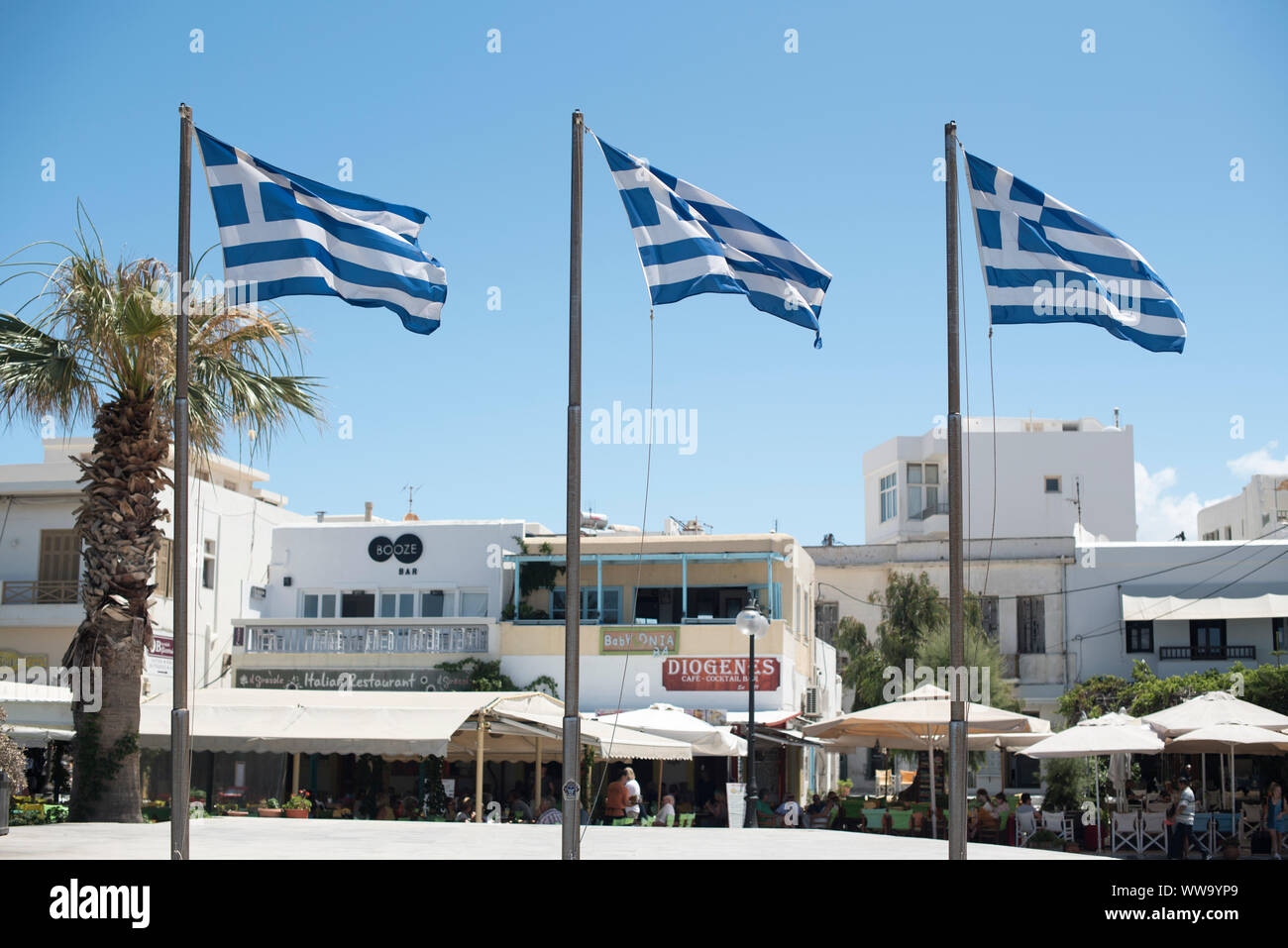 Naxos, Grèce - 29 juin 2018 : trois drapeaux grecs vague en face de restaurants sur l'île de Naxos, une destination populaire pour touristes grecs. Banque D'Images
