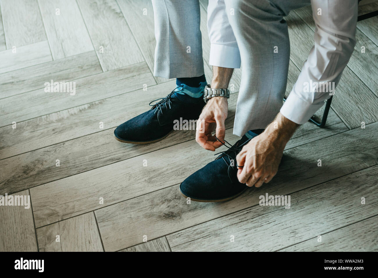 Un homme en pantalon est attacher ses lacets de chaussures à l'intérieur  Photo Stock - Alamy