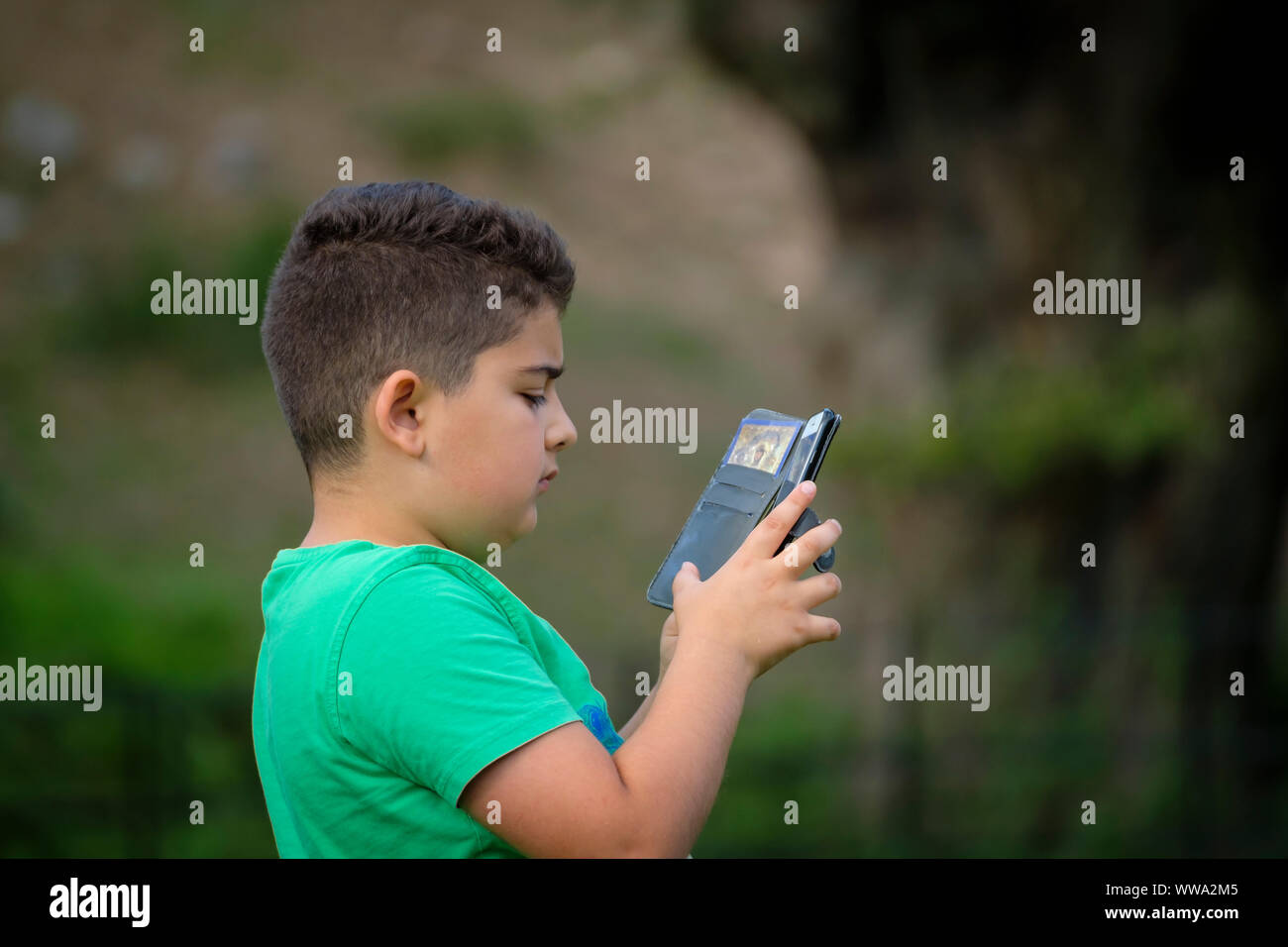 Un garçon à la recherche d'un smartphone. Banque D'Images