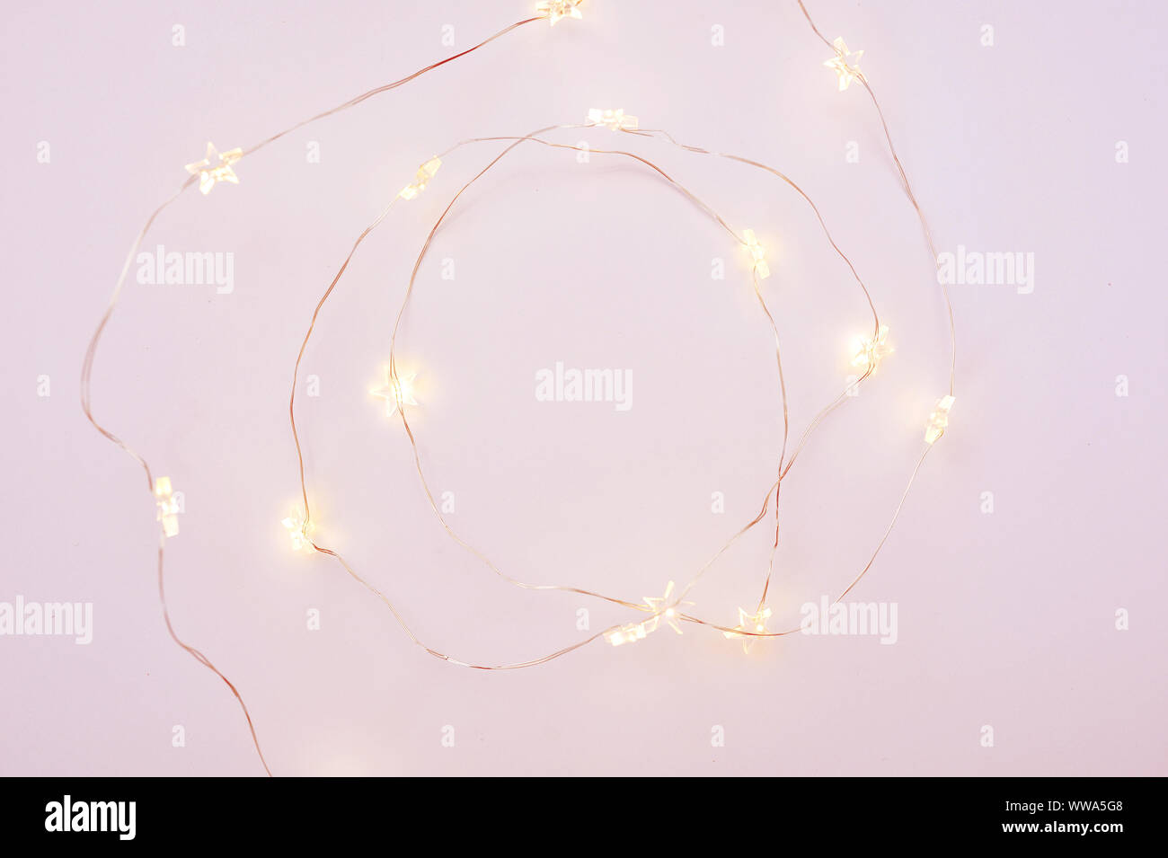 Les lumières de Noël guirlande frontière circulaire sur fond rose avec place pour votre texte. Télévision lay, copy space Banque D'Images