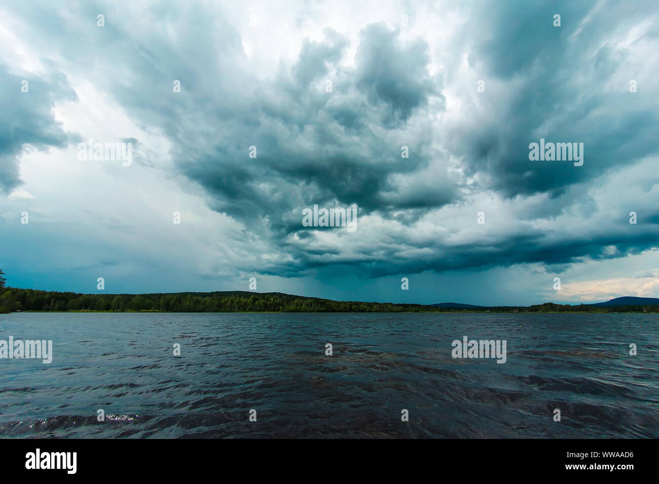 Ciel menaçant au-dessus d'un lac près de Soderhamn et Östersund en Suède. Les nuages orageux bleu foncé reflète dans les eaux sombres. Banque D'Images