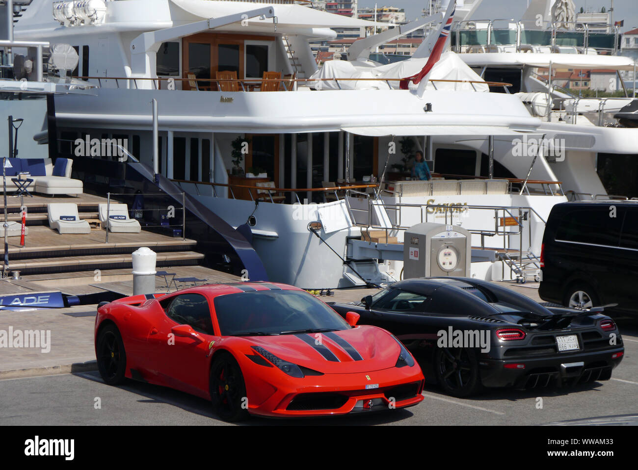 Sports voitures garées par bateau Yacht sur la jetée dans le port de Cannes, Côte d'Azur, France, Union européenne. Banque D'Images