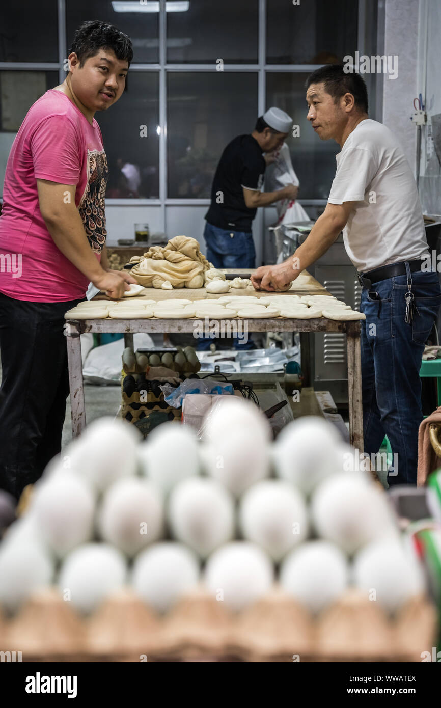 Xian, Chine - Juillet 2019 Les boulangers : faire du pain à partir de pâte à pain dans une petite boulangerie locale sur la rue dans le quartier musulman Banque D'Images