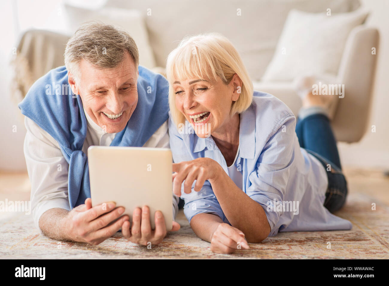 Couple using tablet pc ayant appel vidéo avec petits-enfants Banque D'Images