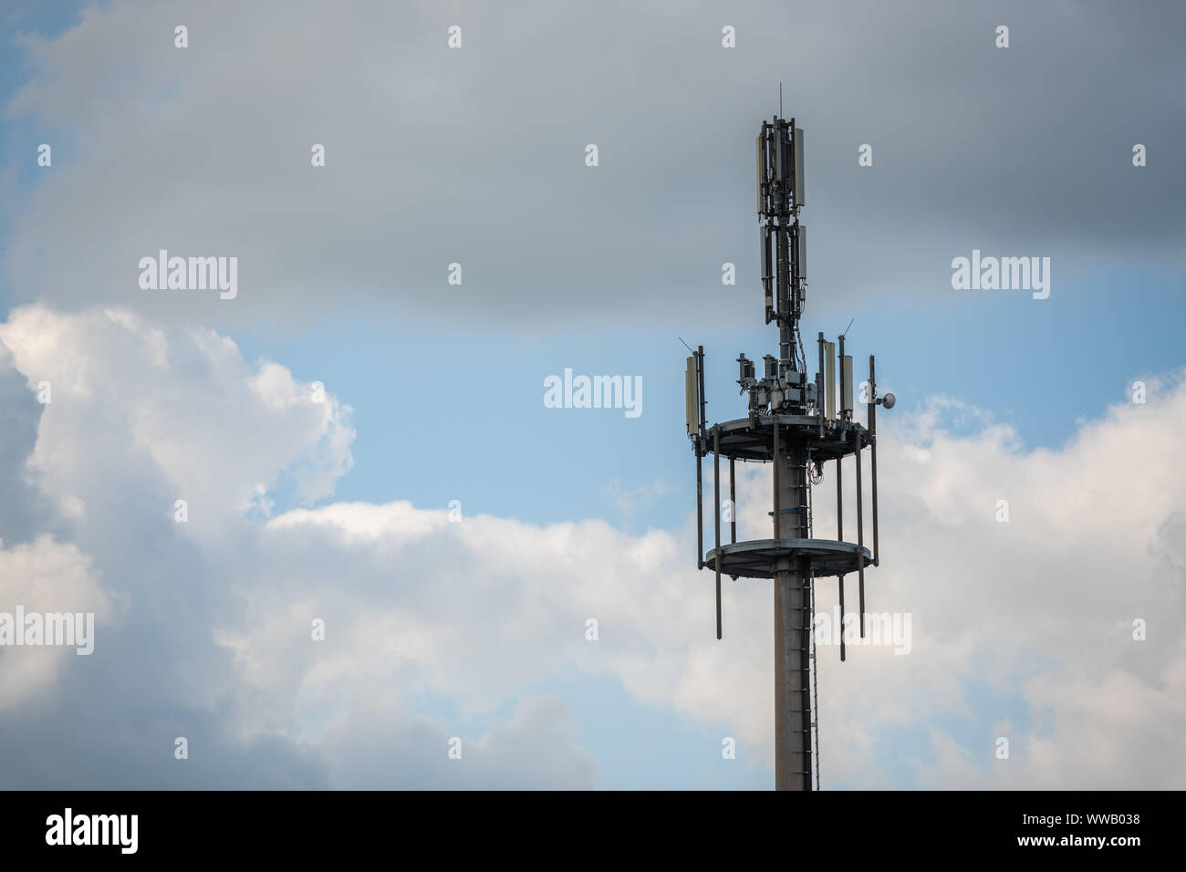Un mât de signaux radio pour les téléphones cellulaires et autres appareils avec ciel bleu et nuages Banque D'Images