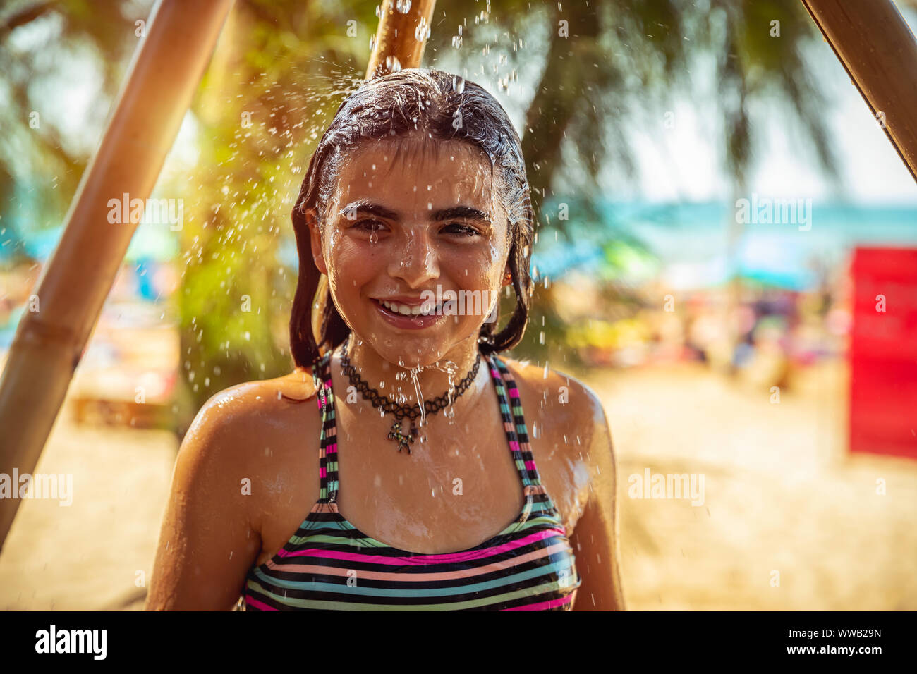 Portrait d'une magnifique petite fille sur la plage resort, enfant heureux de prendre douche sur la plage, s'amuser en plein air, profitant des vacances d'été Banque D'Images