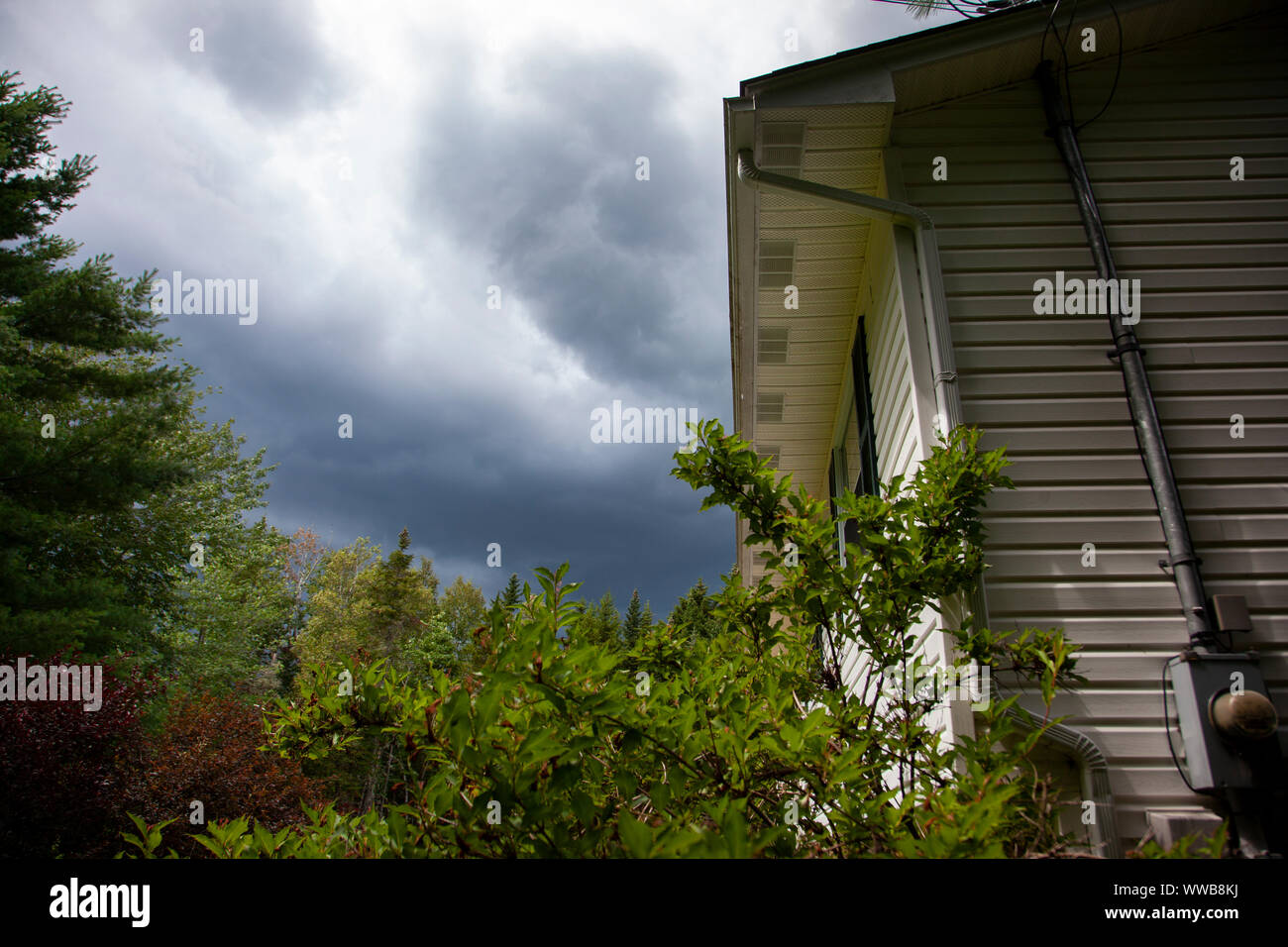 Sombres nuages au-dessus du toit d'une maison avant une tempête Banque D'Images