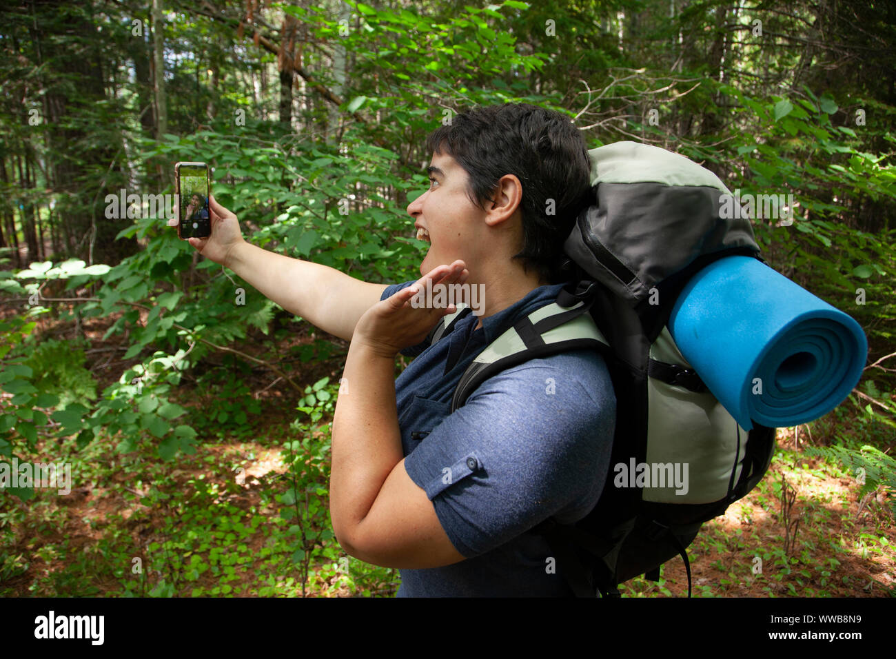 Personne qui représente un autoportrait en vain pour l'extérieur, dans la nature avec leur téléphone cellulaire Banque D'Images