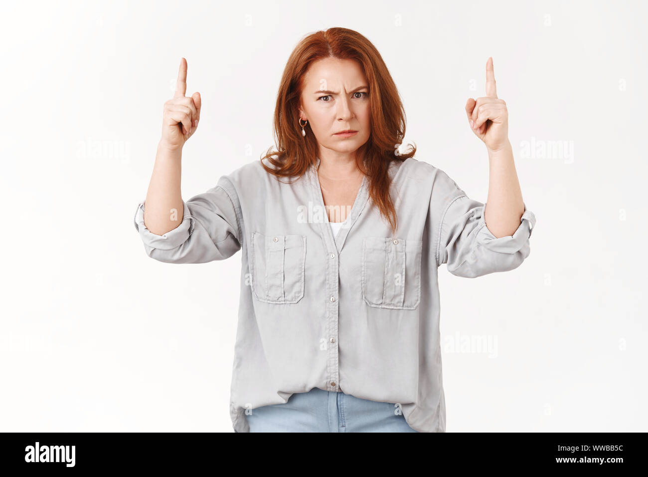 Expliquez-vous jeune homme. Mécontents en colère rousse d'âge moyen mère froncer pointant vers le haut, l'index ennuyé dangereuses stare gronder de l'appareil photo Banque D'Images