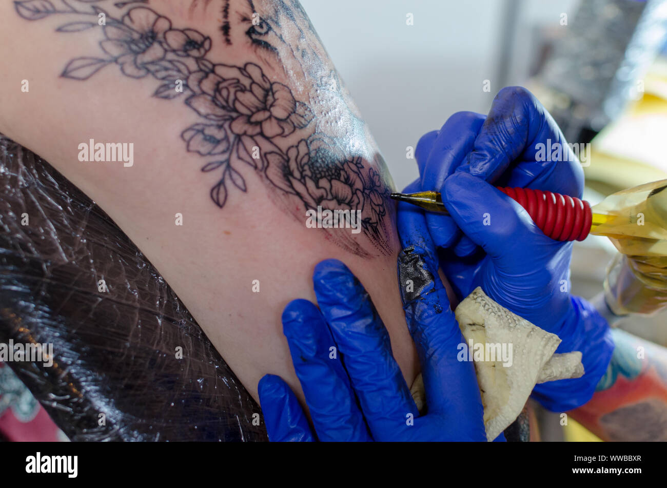 WROCLAW, Pologne - 11 août 2019 : concours de tatouage. Processus de tatouage floral sur une femme bras supérieur. Close-up, selective focus Banque D'Images