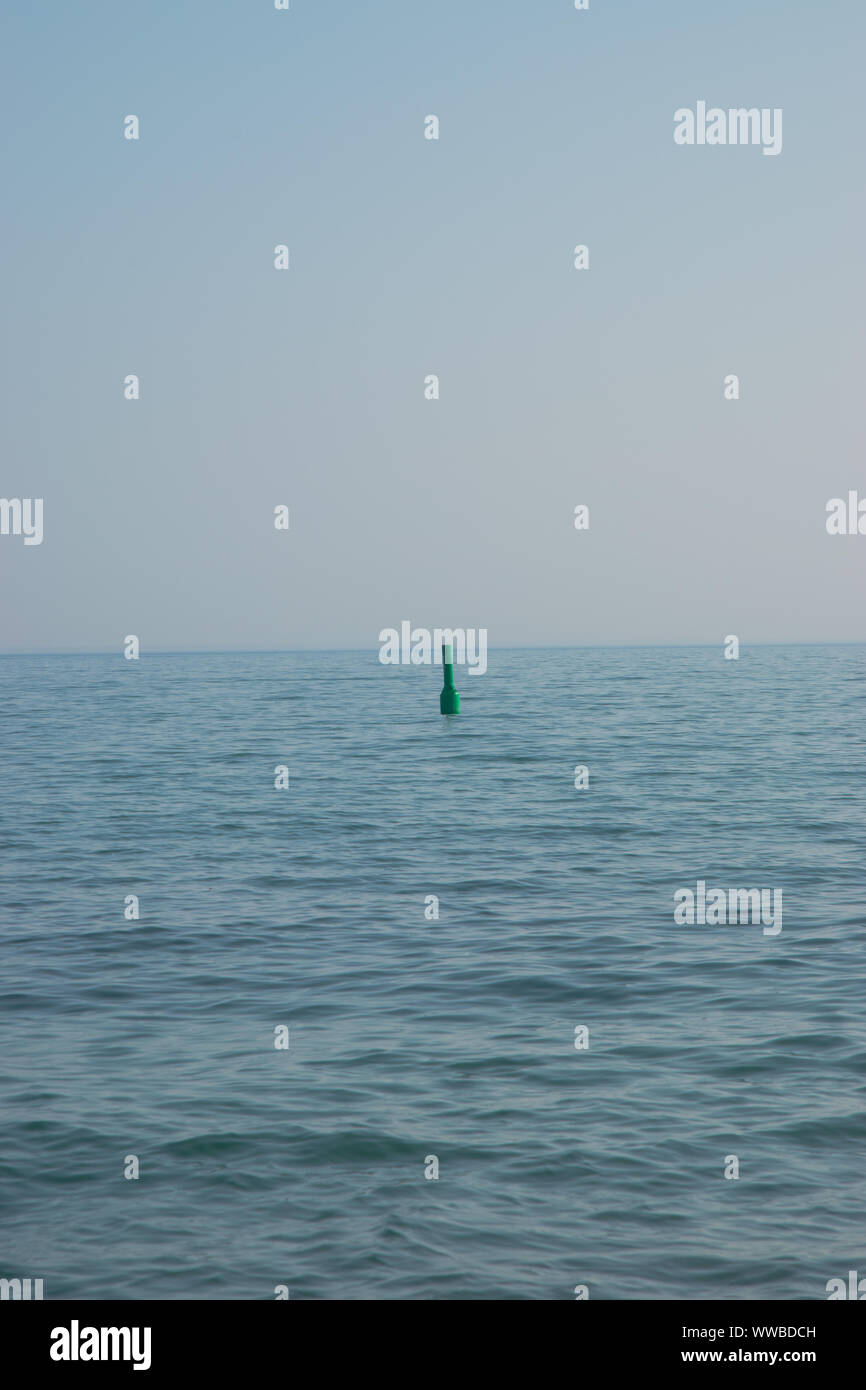 La bouée verte à l'horizon moyen de l'eau Banque D'Images