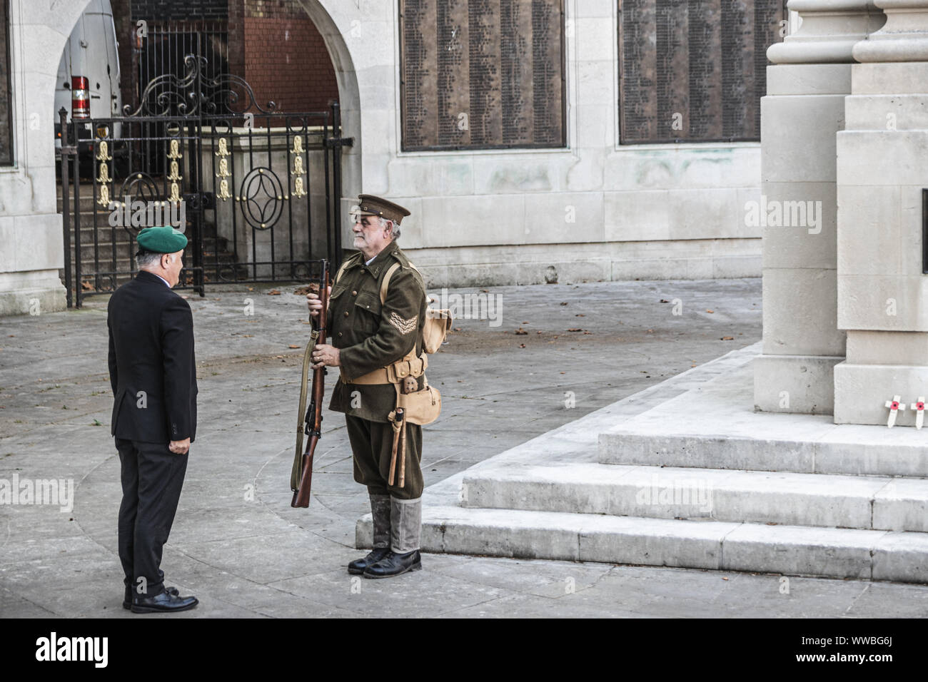 Un homme de la première guerre mondiale uniforme des soldats de la remise d'une veillée d'un ancien combattant de la guerre moderne à un monument commémoratif de guerre Banque D'Images