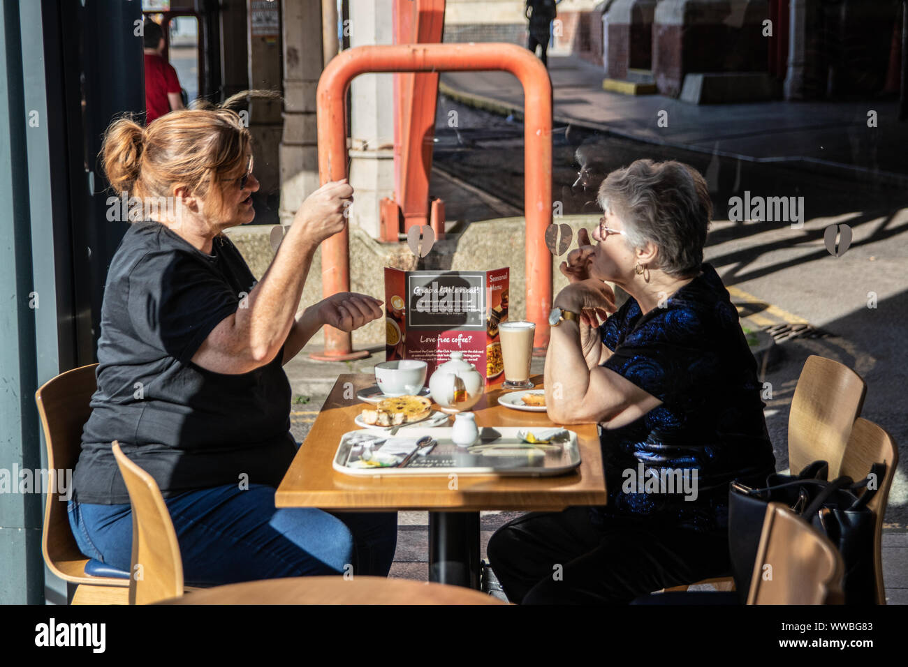 Une femme d'âge moyen et de sa mère âgée de parler tout en ayant un café dans un café Banque D'Images